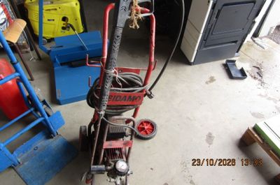 un petit diable auquel est fixé un tuyau, dans un garage