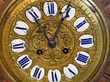 a gold clock with blue and white roman numerals on it