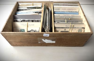 a wooden box filled with books on top of a white table
