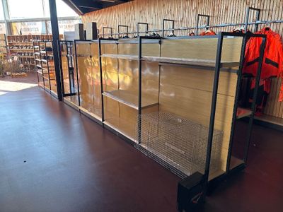 a display case in the middle of a store filled with clothing
