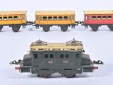 quatre petits trains miniatures posés sur une surface blanche, avec un fond blanc