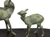 two statues of animals that are on a black table