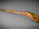 une vieille pipe sur laquelle sont gravés des caractères, posée sur une table