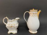 two white and gold vases sitting next to each other on a table