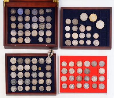 trois boîtes en bois contenant des pièces d'argent, posées sur une surface blanche