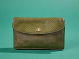 un petit sac à main vert posé sur une surface verte