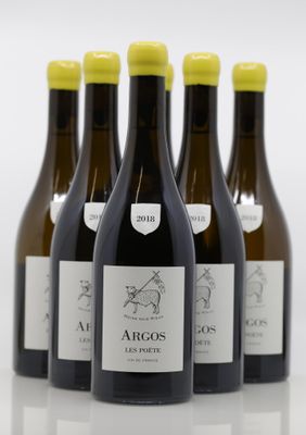 six bottles of wine are lined up in a row on a white surface