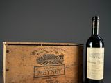 a bottle of wine sitting next to a wooden box on a table