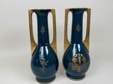 pair of blue vases with gold decoration on them on a white background
