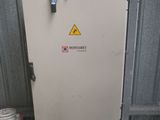 a metal cabinet with a sign on it next to a bucket of paint