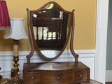une table sur laquelle se trouvent un miroir et une lampe