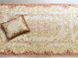 un tapis rouge et doré sur lequel est posé un coussin