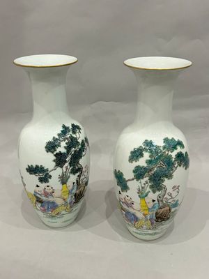 pair of chinese vases with asian scenes on them sitting on a white surface
