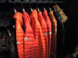 many coats hanging on a rack in a room