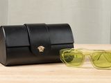 sunglasses and case sitting on a table with a curtain in the background