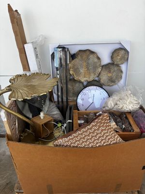 a cardboard box with various items in it sitting on the floor