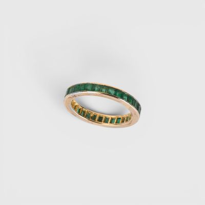 un gros plan sur une bague en or sertie d'émeraudes