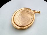 a gold locke with a medallion on it on a white plate