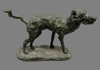 statue of a dog on a rock on a gray background