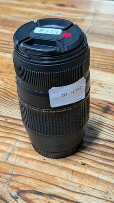 a camera lens on a wooden table with a tag on it