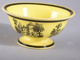 yellow bowl with black and white design on it sitting on a gray surface