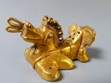 a gold figurine of a man riding a horse