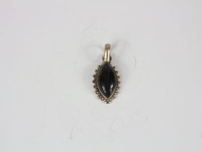a silver and black stone pendant on a white surface