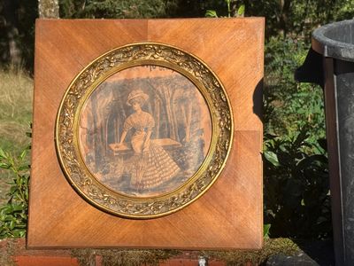 a picture of a picture of a woman in a dress on a plaque