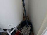 a white tank sitting in the corner of a room with tools on the floor