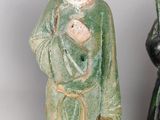 two ceramic figurines of a man and a woman with a bird on their shoulder
