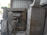 a man standing next to a machine in a garage