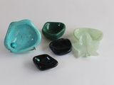 quatre morceaux de verre vert et noir sur une surface blanche