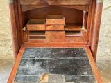 an old wooden desk with a black slate top on a brick floor