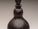 an image of a small bottle with a face on it