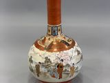 a vase with a painting on it sitting on a table