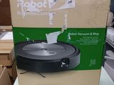 un robot aspirateur et laveur dans une boîte posée sur une table dans un magasin