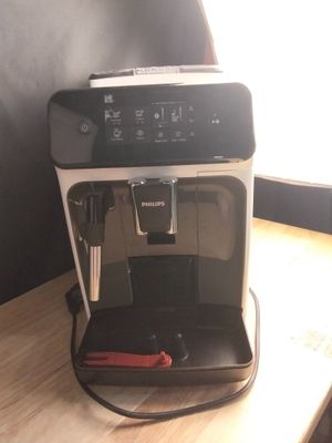 une cafetière noire et blanche posée sur une table en bois