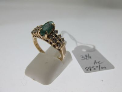 an image of a gold ring with a green stone on it