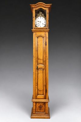 une vieille horloge de parquet en bois, avec un cadran blanc sur fond gris