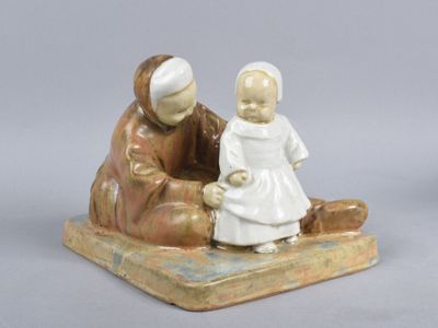une figurine représentant un homme et une femme assis sur un banc