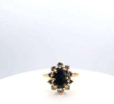 a close up of a gold ring with a black stone surrounded by white diamonds