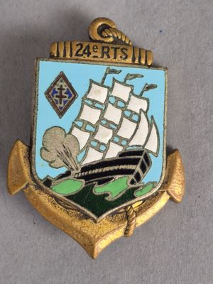 une broche dorée et bleue sur laquelle est représenté un bateau