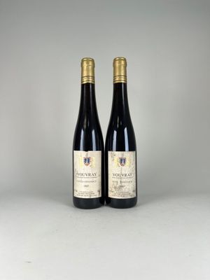 deux bouteilles de vin posées sur une table l'une à côté de l'autre