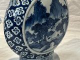 a blue and white vase with a bird on it