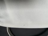 a close up view of a white purse on a black surface