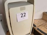 a small white refrigerator sitting on the floor next to a wall