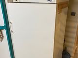 un réfrigérateur blanc sur lequel sont posés des casseroles, dans une cuisine