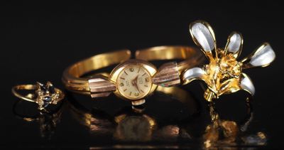 deux bagues et une montre posées sur une surface noire