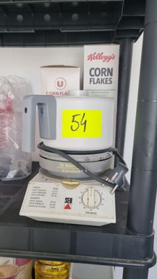 une étagère sur laquelle se trouvent un micro-ondes et d'autres ustensiles de cuisine