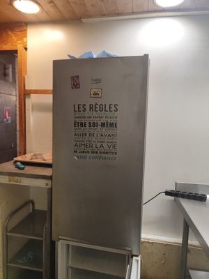 un réfrigérateur qui se trouve dans le coin d'une pièce